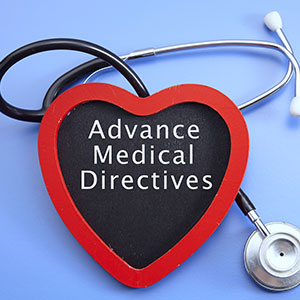 A stethoscope is wrapped around a heart-shaped board that says Advance Medical Directives.